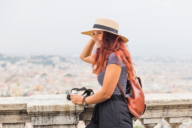 Female tourist with camera on balcony