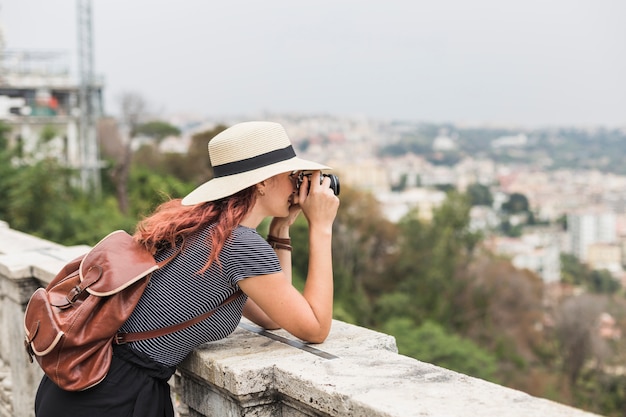 Женский турист с камерой на балконе