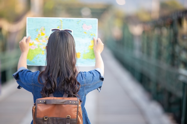 Female tourists on hand have a happy travel map.