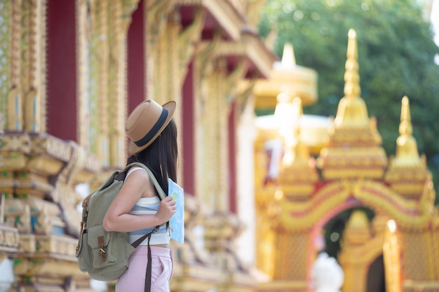 Female tourists hold a map to find places.