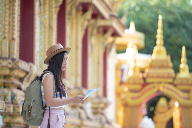 Female tourists hold a map to find places.