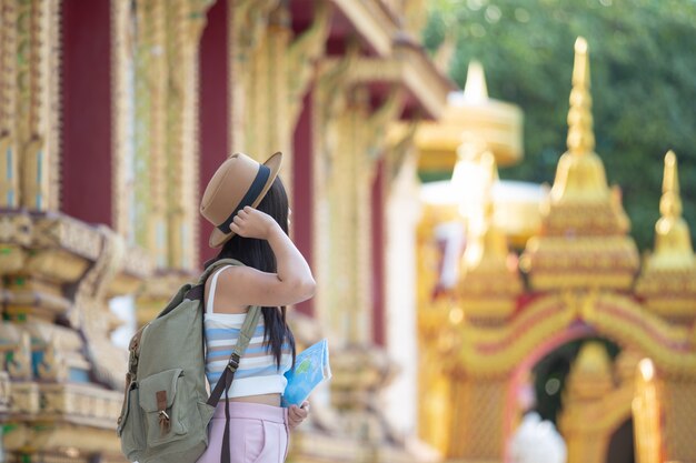 Female tourists hold a map to find places.