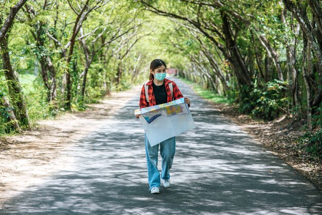 女性観光客が立ち、道路上の地図を見る。