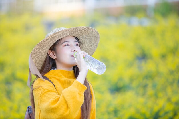 여성 관광객은 걷는 동안 식수를 유지합니다.