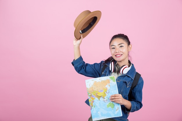 Turisti femminili in studio su uno sfondo rosa.