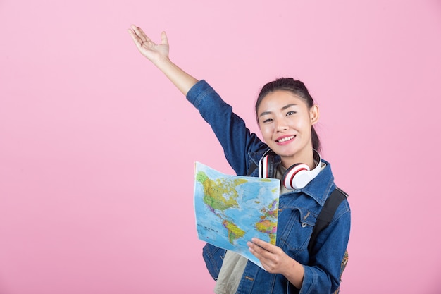 Turisti femminili in studio su uno sfondo rosa.