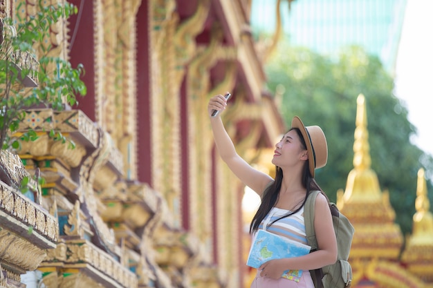 女性観光客が携帯電話で写真を撮る