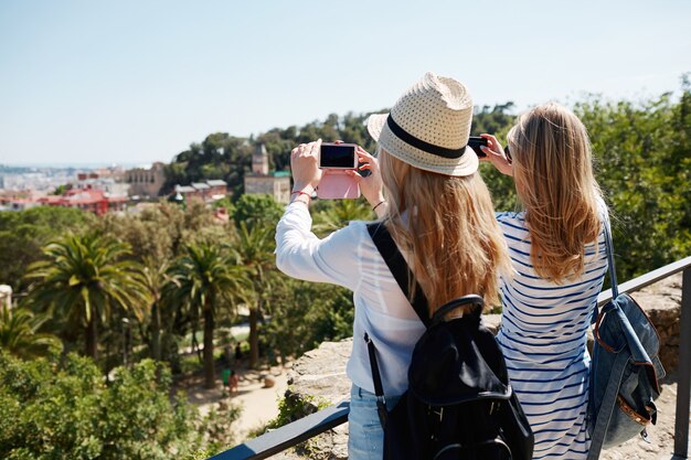 Female tourists taking photos in park