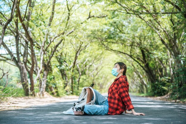 Female tourists wearing a mask to sit and relax on the street.