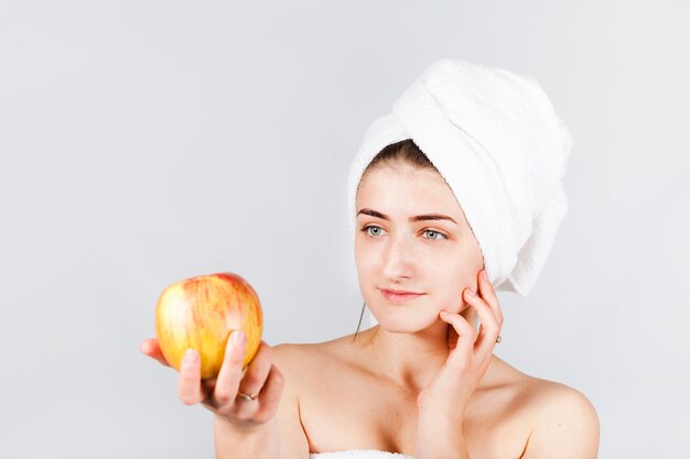 Female in towel holding bright apple