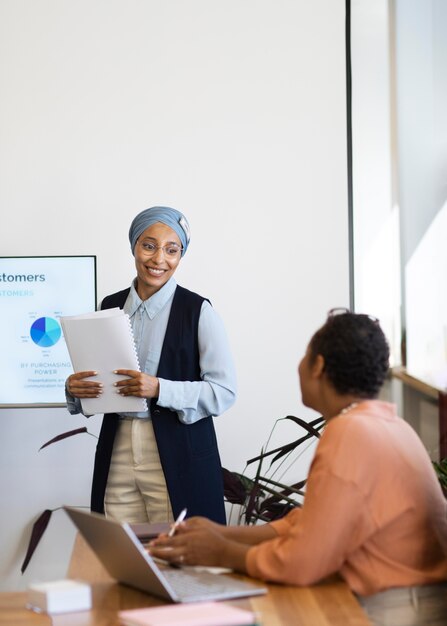 Female trainers at office job prepare for a session with new employee