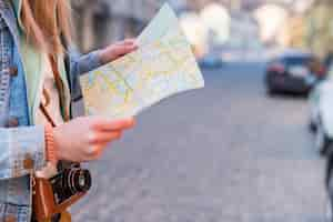 Foto gratuita viaggiatore femminile che cerca direzione sulla mappa di posizione nel centro urbano