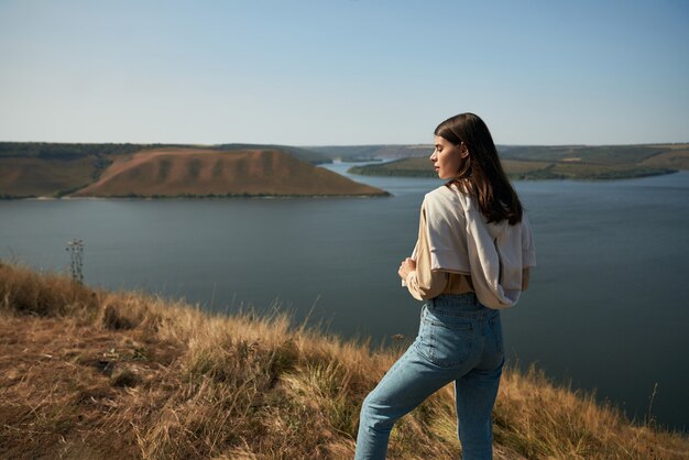 バコタ湾の岩の端に立っている女性旅行者