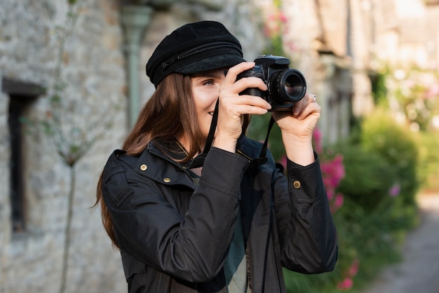 新しい思い出のためにプロのカメラを使用している女性旅行者