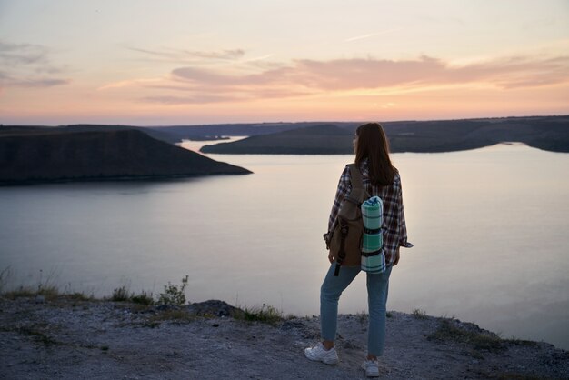 Female traveler with backpack standing on hill at bakota bay