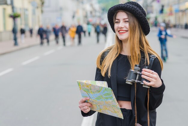 Foto gratuita viaggiatore femminile con la mappa e il binocolo