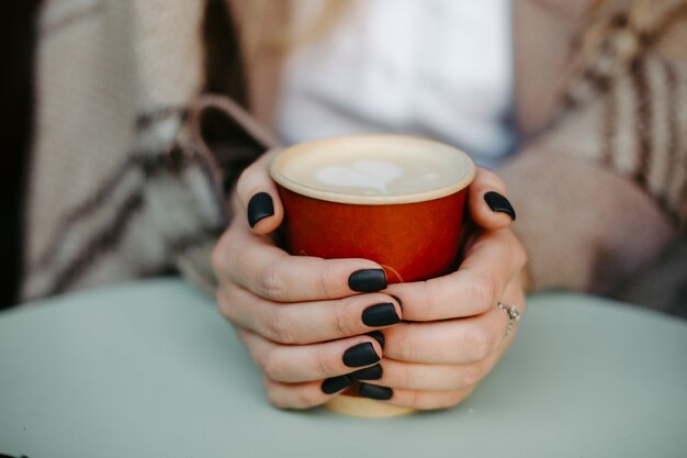 여성 두 손은 커피와 함께 흰색 테이크 아웃 컵을 들고