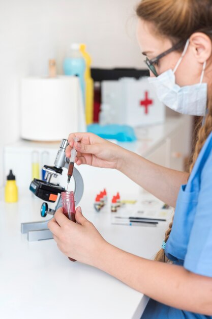 Female veterinarian examining blood sample in clinic