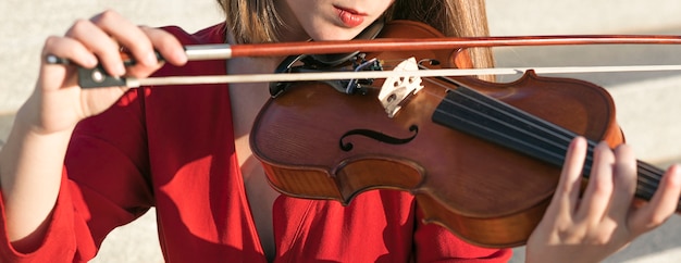 Бесплатное фото Женский скрипач играет с инструментом и лук