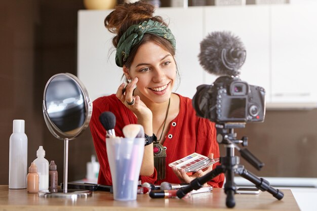 Female vlogger filming makeup video