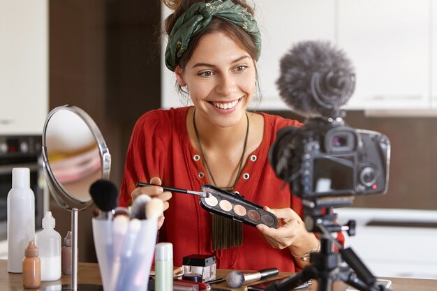 Female vlogger filming makeup video