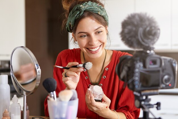 Female vlogger filming makeup video