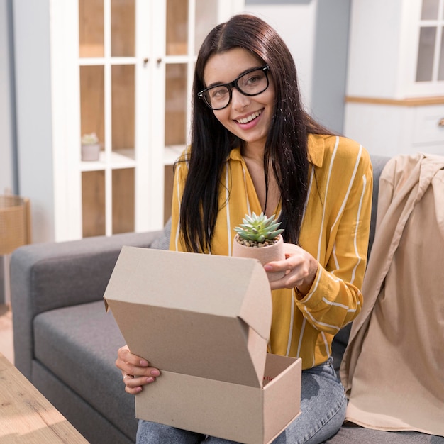 Free photo female vlogger at home unboxing plant