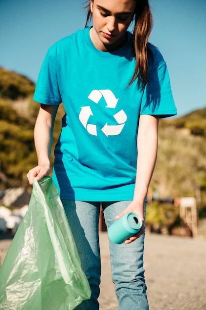 Free photo female volunteer collecting trash at the beach