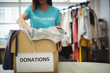 Free Photo | Female volunteer holding clothes in donation box