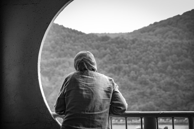 Female wearing a hijab standing on a balcony in black and white