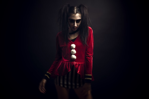 Free photo female wearing a velvet red costume and a scary makeup on her face standing