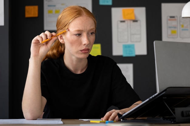 Free photo female web designer in the office with laptop