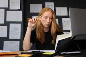 Free photo female web designer in the office with notebook