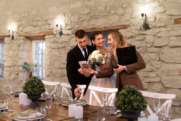 Female wedding planner working with bride and groom