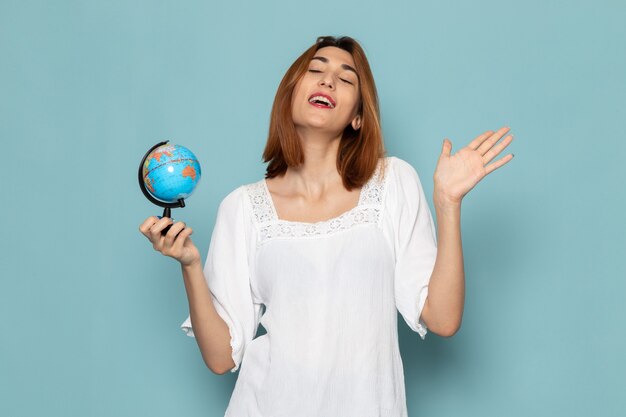 female in white blouse and blue jeans holding little globe