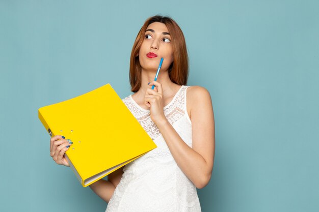 female in white blouse and blue jeans holding yellow files