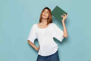 Free photo female in white blouse and blue jeans thinking and holding green copybook