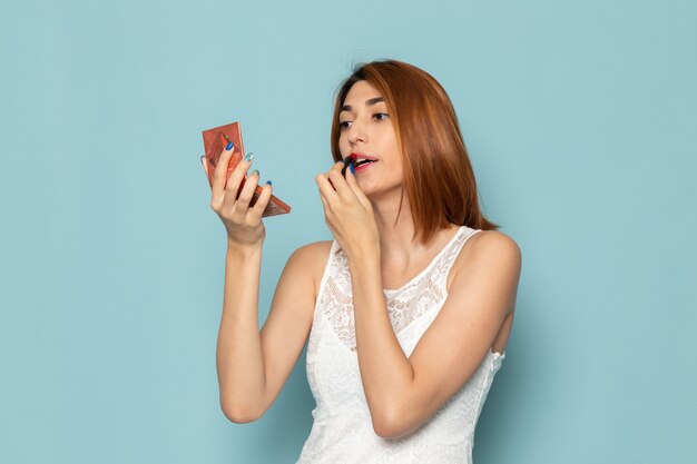 female in white dress posing and doing make-up