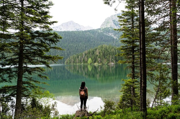 Female with a backpack enjoying view of the Black Lake in Durmitor National Park, Montenegro