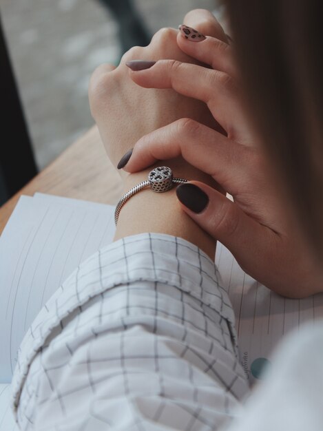 Female with a fashionable silver bracelet with a pendant