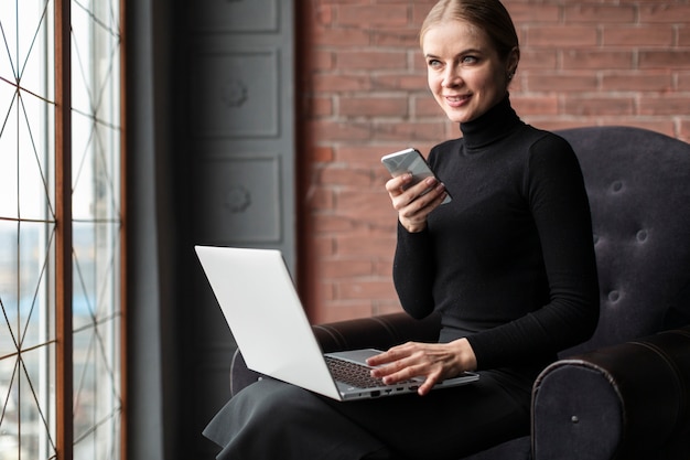 Femmina con laptop e telefono