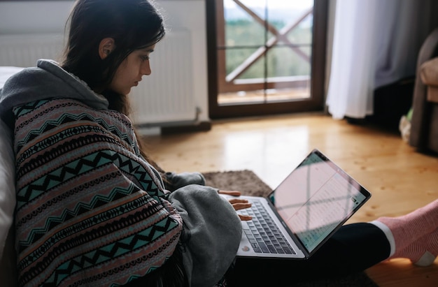 Foto gratuita femmina con laptop seduto sul pavimento e lavorando sul laptop