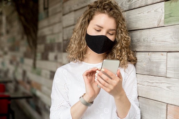 Foto gratuita femmina con maschera tramite telefono