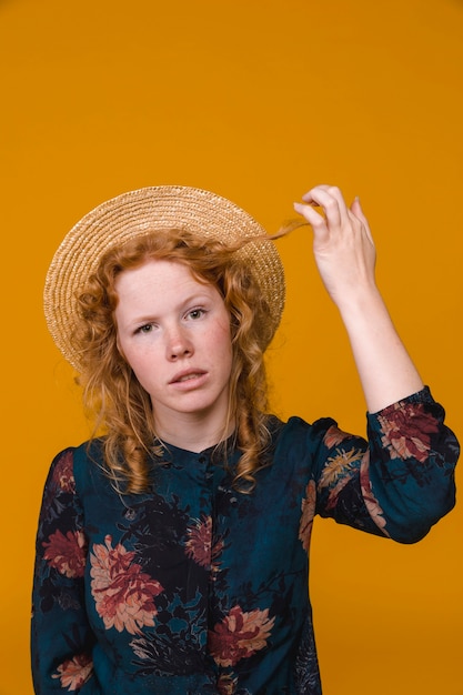 Female with perplexity touching ginger hair in studio