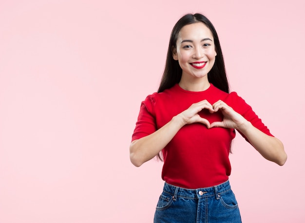 Female with red lips showing heart sign