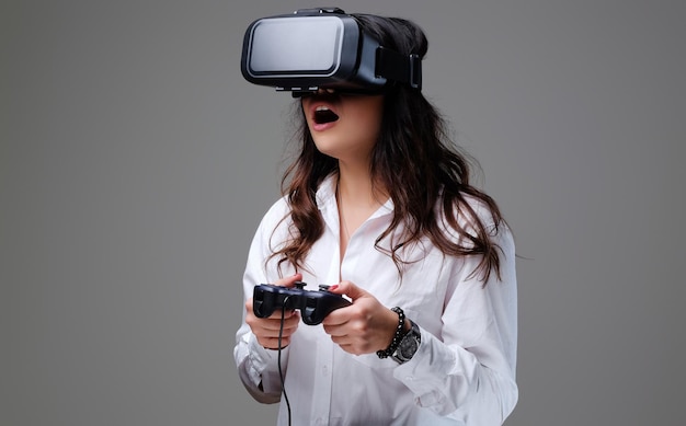 재미있는 VR 안경을 쓴 여성. 회색 배경에 고립.