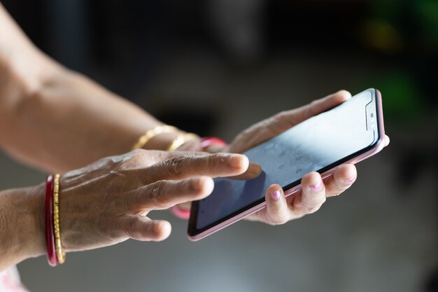 Female with wrinkled hands using a smartphone