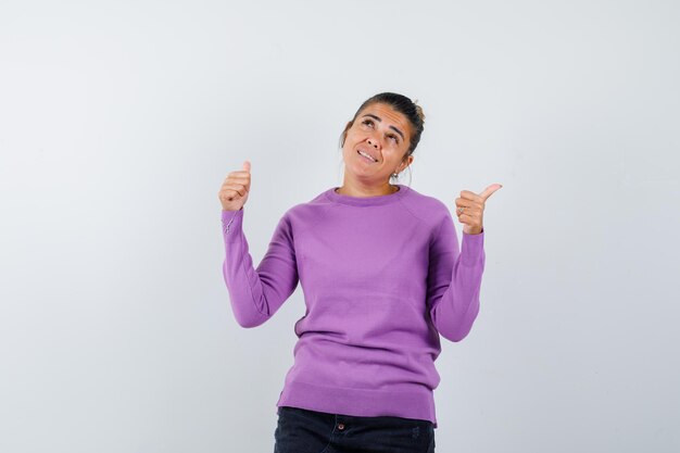 Female in wool blouse showing double thumbs up and looking happy 