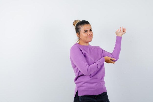 Female in wool blouse showing something or welcoming and looking cheery 