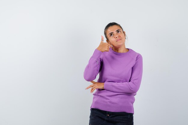 Female in wool blouse showing thumb up and looking hopeful 